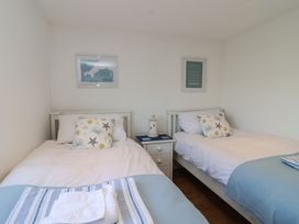 A bedroom with two single beds and a nightstand at Stella Maris in Torpoint