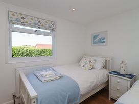 A bedroom with two beds and a window at Stella Maris in Torpoint