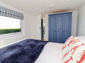 A bedroom with a bed and blue wardrobe at Stella Maris in Torpoint