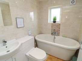 A bathroom with a bathtub, wash basin, and toilet at James Ville Marina Lodge 22 Brigg