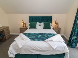 A bedroom with a bed, side table, and dresser at James Ville Marina Lodge 22, Brigg