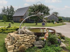 A pond with a dragonfly sculpture and decorative bird at James Ville Marina Lodge 22 in Brigg