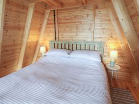 A bedroom featuring a bed, bedside table, and lamp at Robin in Monewden near Otley, Suffolk