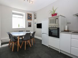 A kitchen with a table and chairs at Cwtch y Môr in Trearddur Bay