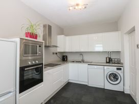 A kitchen with appliances and cabinets at Cwtch y Môr in Trearddur Bay