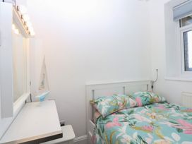 A bedroom with a bed and a vanity at Cwtch y Môr in Trearddur Bay
