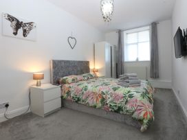 A bedroom with a bed and wardrobe at Cwtch y Môr in Trearddur Bay