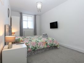 A bedroom with a bed and television at Cwtch y Môr in Trearddur Bay