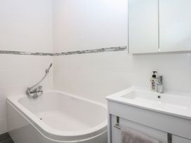 A bathroom with a bathtub and sink at Cwtch y Môr in Trearddur Bay