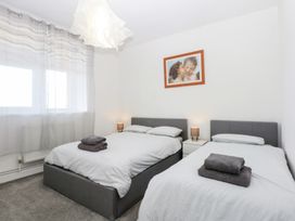 A bedroom with two beds and a window at Cwtch y Môr in Trearddur Bay