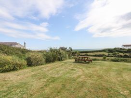 An outdoor space with a picnic table and grass at Cwtch y Môr Trearddur Bay
