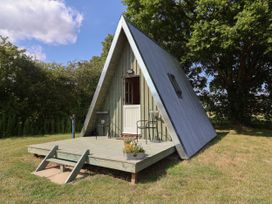 A cabin with a deck and chairs at 1 Bed Sleeps 2, Shared Bathroom in Monewden near Otley, Suffolk
