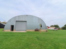 A metal hangar with airplanes and a bench at Oak Tree in Monewden near Otley, Suffolk