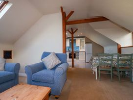 A living room with sofas and a dining area at The Stables in Falmouth