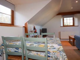 A dining room with a table and chairs at The Stables in Falmouth