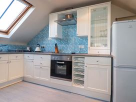 A kitchen with appliances and cabinets at The Stables in Falmouth