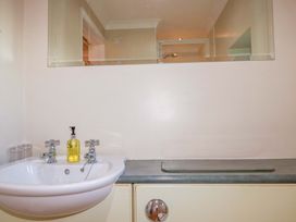 A bathroom sink with faucets and soap dispenser at The Stables in Falmouth