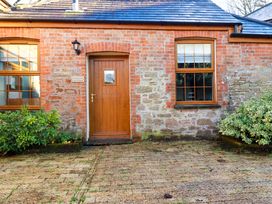 A brick wall with a door and window at Farrier Cottage in Falmouth