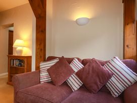 A living room with a sofa and lamp at Farrier Cottage in Falmouth