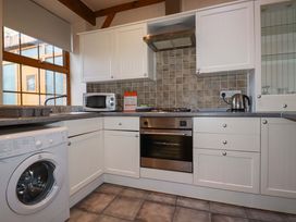 A kitchen with appliances and cabinets at Farrier Cottage in Falmouth