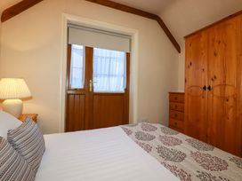 A bedroom with a bed and a wardrobe at Farrier Cottage in Falmouth
