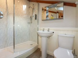 A bathroom with a shower, sink, and toilet at Farrier Cottage in Falmouth