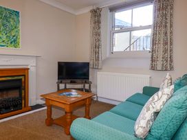 A living room with a sofa and television at Horseshoe Cottage in Falmouth
