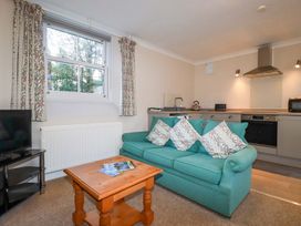 A living room with a sofa and television at Horseshoe Cottage in Falmouth