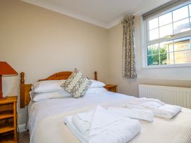 A bedroom with a bed and bedside table at Horseshoe Cottage in Falmouth