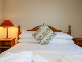 A bed with pillows and a lamp in a bedroom at Horseshoe Cottage in Falmouth