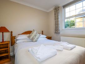 A bedroom with a bed and a bedside table at Horseshoe Cottage in Falmouth