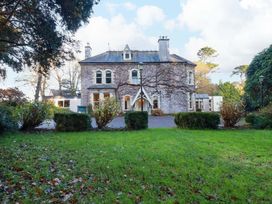 A stone building with windows and a pathway at Horseshoe Cottage in Falmouth