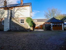 An outdoor area with a building and garage at The Hayloft in Falmouth