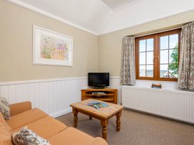A living room with a television and coffee table at The Hayloft Budock Water near Falmouth