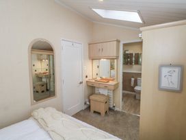 A bedroom with a dressing table and bathroom access at Labernum in Lytham St. Annes