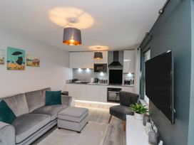 A living room with a sofa and kitchen in Rosie's Retreat Filey
