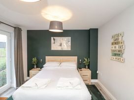 A bedroom with a bed and nightstands at Rosie's Retreat, Filey