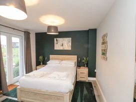 A bedroom with a bed and nightstands at Rosie's Retreat in Filey