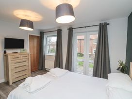 A bedroom with a bed and television at Rosie's Retreat in Filey