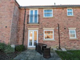 An outdoor area with furniture and a brick wall at Rosie's Retreat in Filey