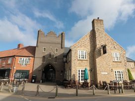 A pub exterior with a gate and outdoor seating at Rosie's Retreat in Filey