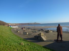 A beach view with cliffs and a promenade at Rosie's Retreat in Filey