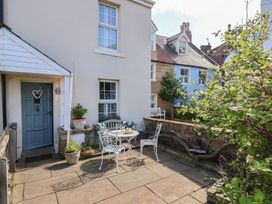 An outdoor seating area with a table and chairs at Woodbine Cottage Whitby