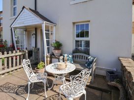 An outdoor seating area with a table and chairs at Woodbine Cottage in Whitby