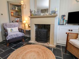 A living room with a fireplace and armchair at Woodbine Cottage in Whitby
