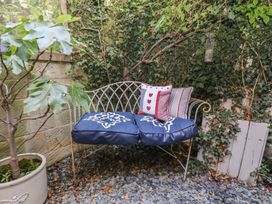 A garden with a bench and cushions at Woodbine Cottage in Whitby