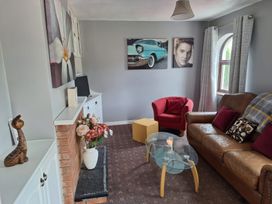 A living room with flower painting and a television at Lilly's Bungalow in Timoleague