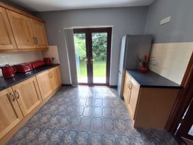 A kitchen with cabinets and a door leading outside at Lilly's Bungalow in Timoleague