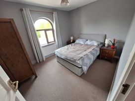 A bedroom with a bed and bedside tables at Lilly's Bungalow in Timoleague