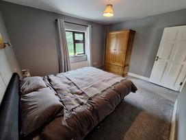 A bedroom with a bed and wardrobe at Lilly's Bungalow in Timoleague